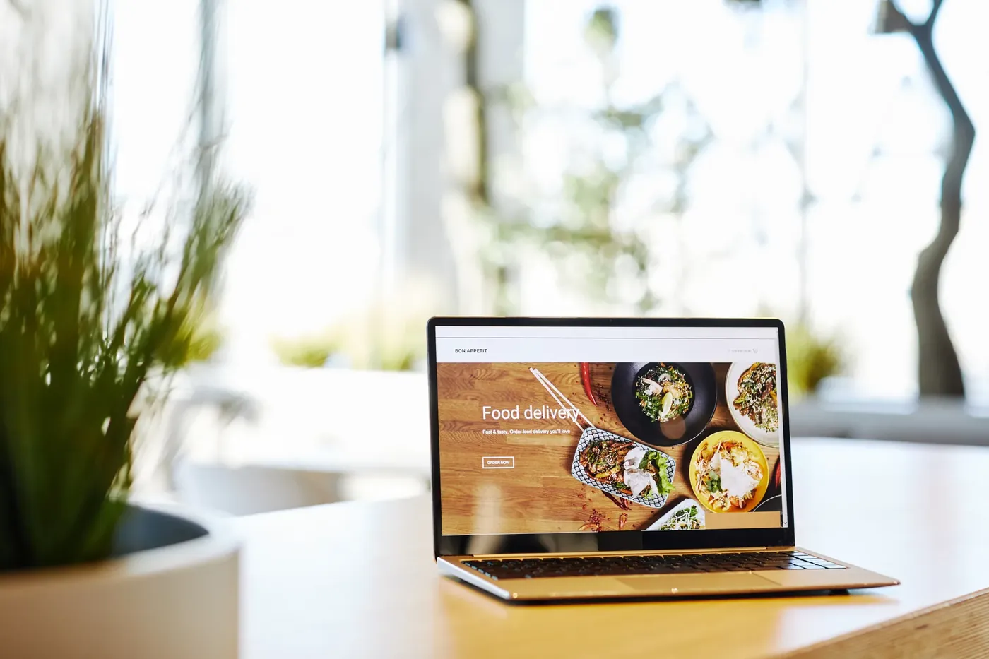 Laptop auf einem Schreibtisch zeigt eine fertige Website mit Startseite und Handlungsaufforderung